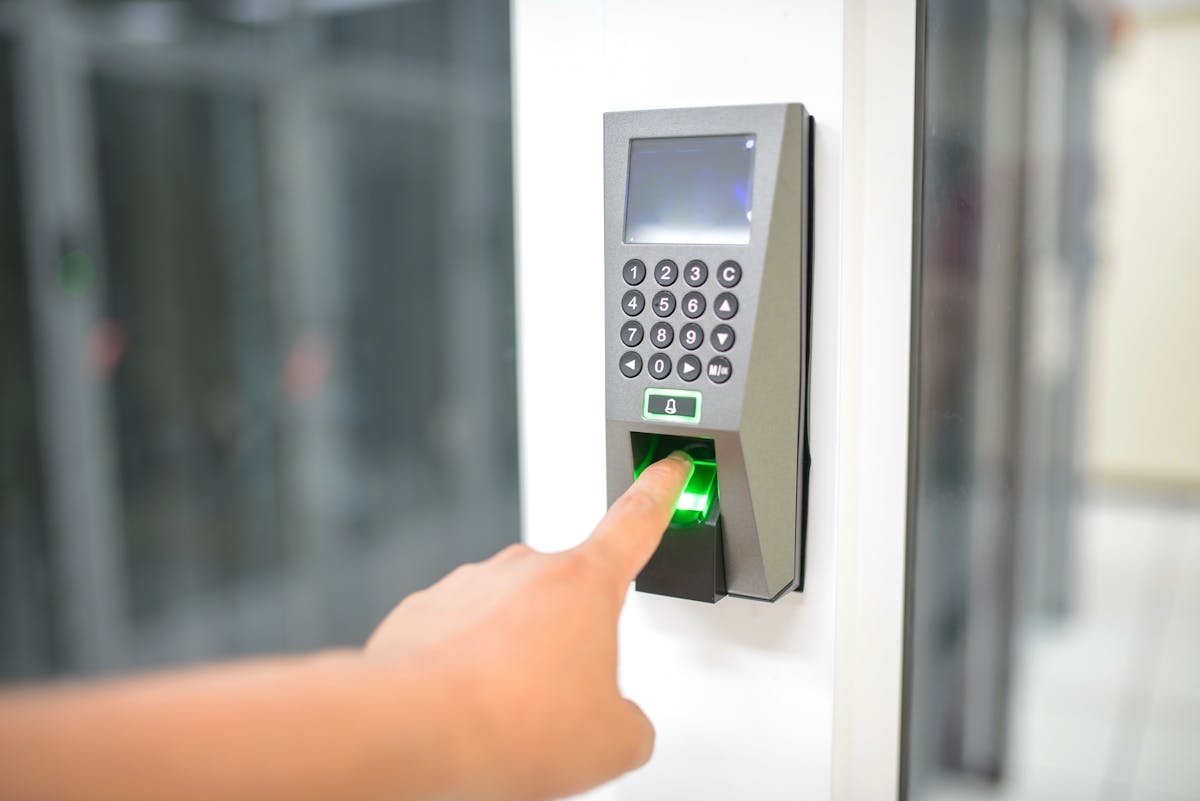 Persona usando lector de huella para acceso seguro a oficina